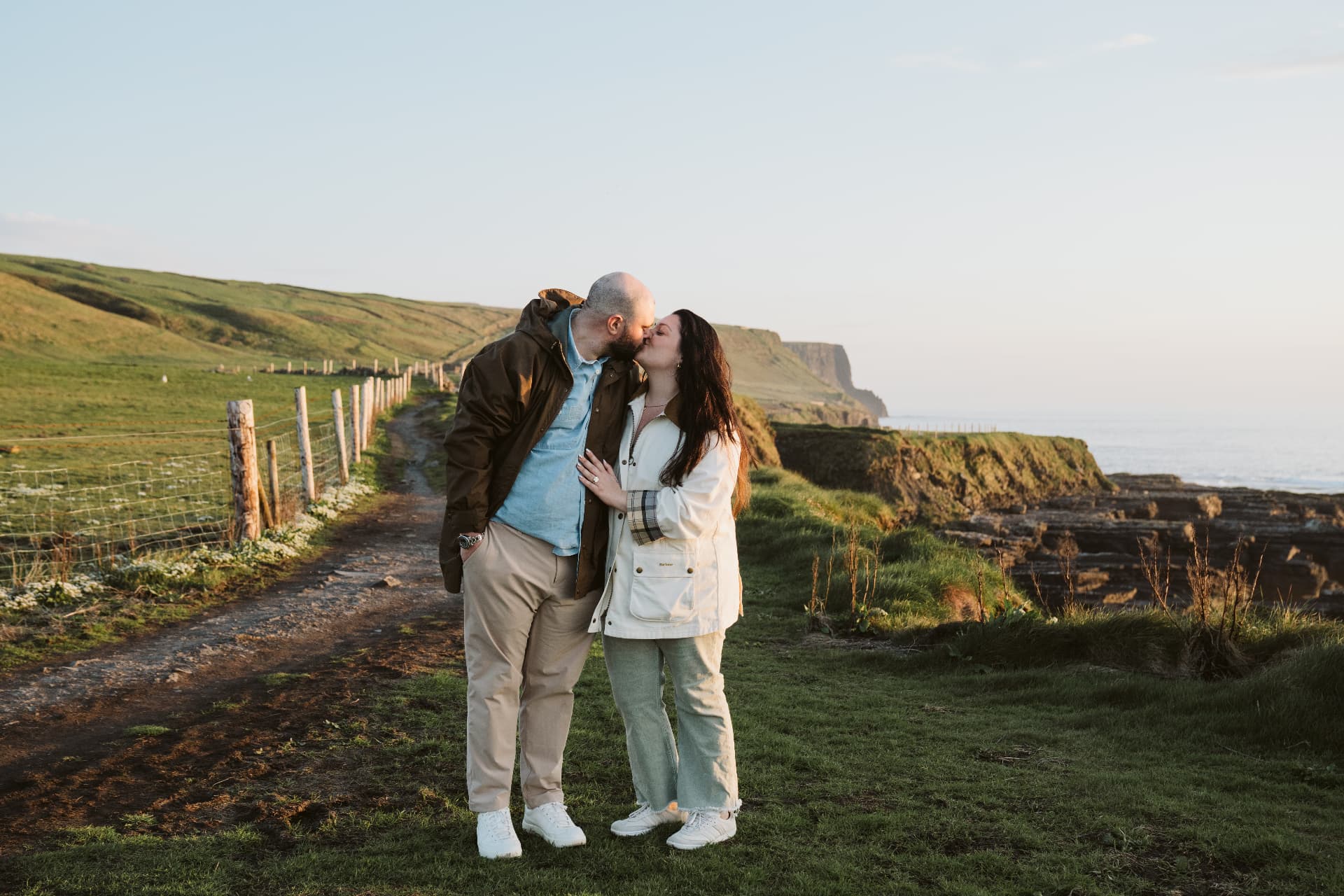 Jaime Cortina and Nolan Maguire kissing on a coastal path above the Cliffs of Moher