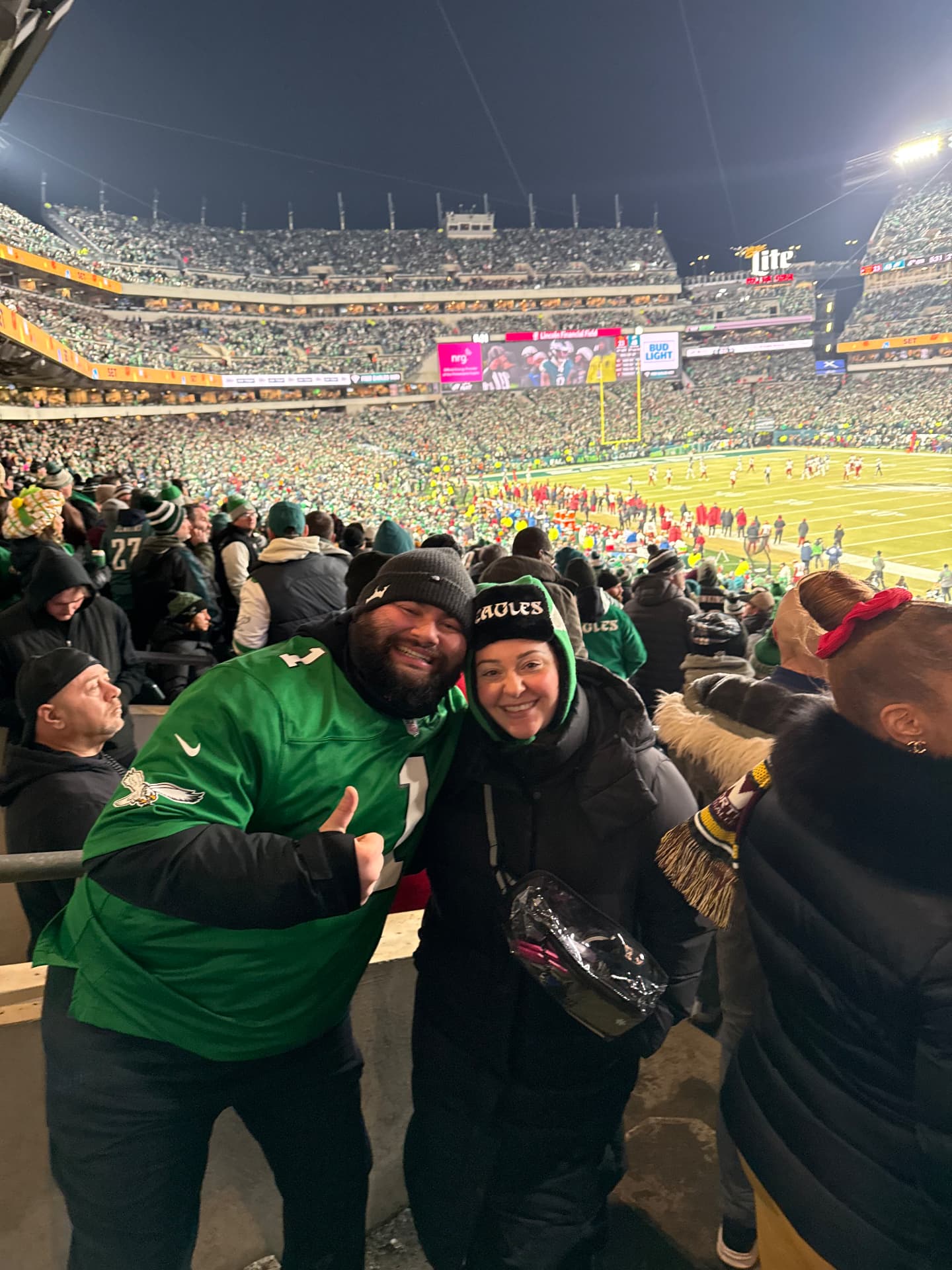 Jaime and Nolan in Eagles gear in a packed stadium