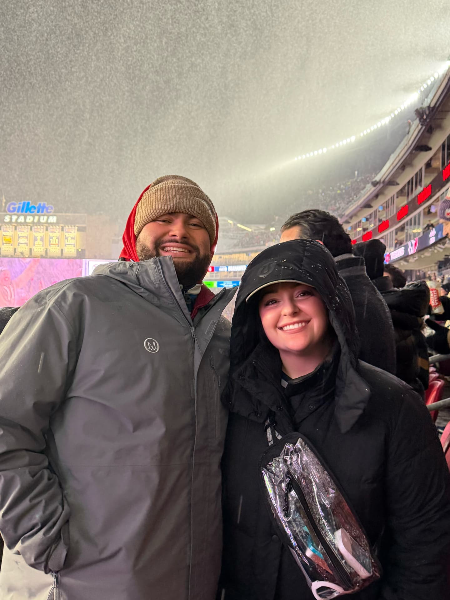 Jaime and Nolan bundled up in the snow at a Patriots game